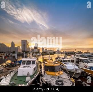 Panorama depuis le port de l'embarcadère d'Osanbashi à Yokohama où des bateaux de pêche colorés sont amarrés au coucher du soleil Banque D'Images