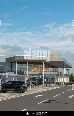 Irvine, Écosse, Royaume-Uni - 15 juin 2020 : les supermarchés de marque Sainsbury sont encore calmes avec des parcs à cardans à moitié vides à Irvine pendant le confinement du Covid-19. Banque D'Images