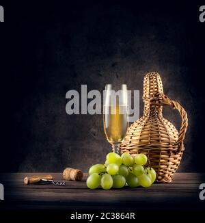 Carafe tressée et un verre de vin blanc sur fond de grange Banque D'Images