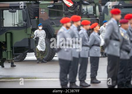 19 juin 2020, Saxe-Anhalt, Burg : les recrues se tiennent lors de la cérémonie du voeu sur la place Apellplatz de la caserne Causewitz. Derrière eux se trouvent des ambulanciers paramédicaux avec des masques et des vêtements de protection. La pandémie de Corona avait également changé le voeu solennel du bataillon de logistique en 171 dans la caserne de Clausewitz à Burg. Contrairement à l'habitude, il n'y avait pas de recrues d'autres unités de Beelitz dans le Brandebourg et de Berlin. Les soldats ont gardé une distance de deux mètres chacun. Ainsi, 23 recrues, dont quatre femmes soldats et 19 hommes soldats, ont prêté serment. Photo: Klaus-Dietmar Gabbert/dpa-Zentralbild/dpa Banque D'Images