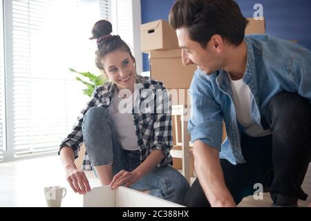 Jeune couple installant des meubles pour la nouvelle maison Banque D'Images