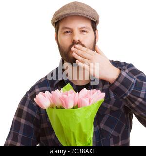 Jeune homme beau barbu tenant un bouquet de tulipes roses Banque D'Images