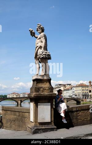 La jeune femme bénéficie d'une glace à l'ombre de Bacchus, Ponte Santa Trinita, Florence, Italie. Banque D'Images