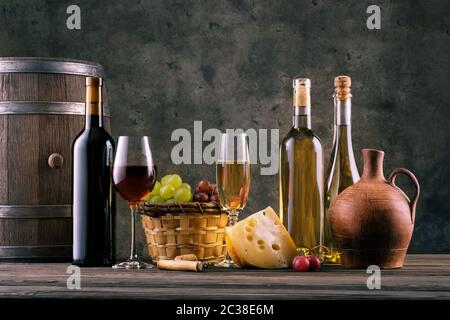 La vie toujours avec des verres de vin de bouteilles et les vignes contre le mur sombre Banque D'Images