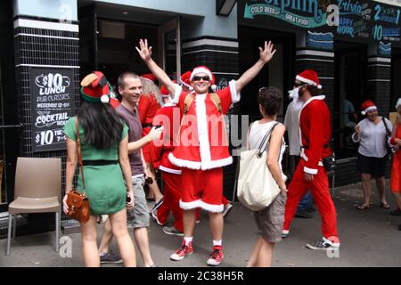 Les personnes qui prennent part au SantaCon habillé comme le Père Noël arrivent au pub Dolphin au 412 Crown Street, Surry Hills. Banque D'Images