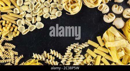 Modèle de conception panoramique de pâtes italiennes avec espace d'écriture, une couche plate d'une variété de types de pâtes, tiré du dessus sur un bac noir Banque D'Images