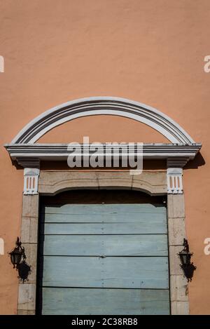 Porte en bois flanquée de deux lumières et d'un fronton d'arche sur des maisons peintes en pastel, Valladolid, Yucatan, Mexique Banque D'Images