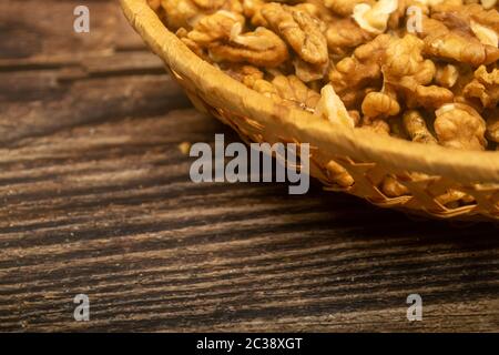 Noix pelées dans un panier en osier sur une table en bois. Une alimentation saine. Régime de remise en forme. Gros plan Banque D'Images