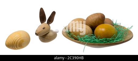 En bois tourné à la main les oeufs dans un petit bol en bois avec toy lapins de Pâques isolated on white Banque D'Images