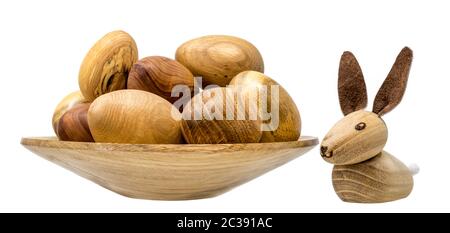 En bois tourné à la main les oeufs dans un petit bol en bois avec toy lapins de Pâques isolated on white Banque D'Images