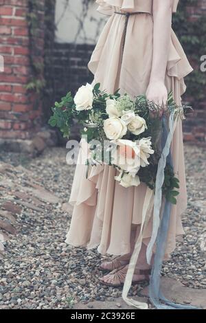 Femme en robe boho avec bouquet luxuriant Banque D'Images