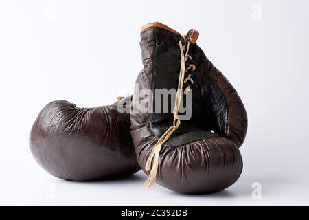 Vintage paire de gants de boxe en cuir brun sur un fond blanc, l'équipement de sport. Arrière-plan de remise en forme. Banque D'Images