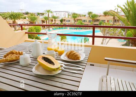 Chambre d'hôtel Petit-déjeuner sur le balcon vue sur piscine et palmiers. Voyage Vacances alimentaire matin petit déjeuner en complexe hôtelier de luxe à l'extérieur. Banque D'Images
