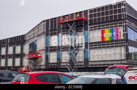 Une bannière NHS de support de couleur est suspendue à un nouveau projet de construction de bâtiments sur l'ancien site du marché Basildon. Travailleurs de la construction au travail. Banque D'Images