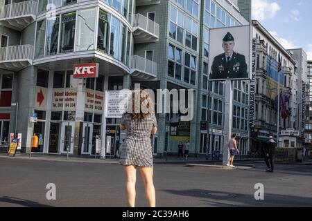 Une femme prend une photo à Checkpoint Charlie sur Friedrichstrasse, point de passage du mur de Berlin entre Berlin est et Berlin Ouest pendant la Guerre froide. Banque D'Images