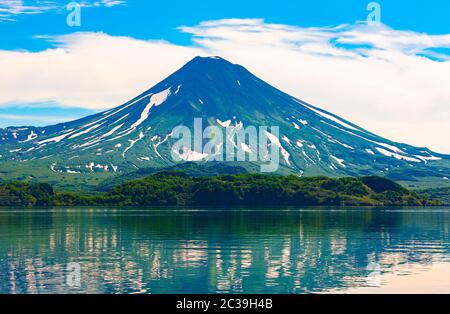 Le pittoresque reflet d'été du volcan Ilyinsky dans l'eau du lac Kurile. Sanctuaire du Kamchatka du Sud, Russie Banque D'Images