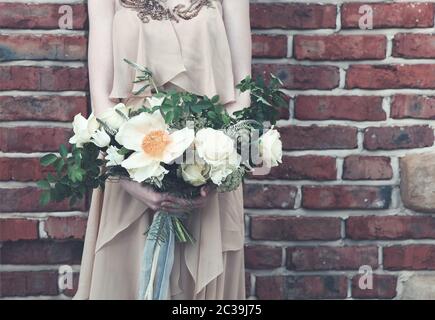 Femme en robe boho avec bouquet luxuriant Banque D'Images