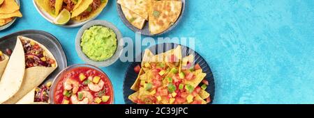 Cuisine mexicaine panoramique top shot avec espace de copie, une plate-forme sur un fond bleu. Nachos, guacamole, cocktail de crevettes, burritos, Banque D'Images