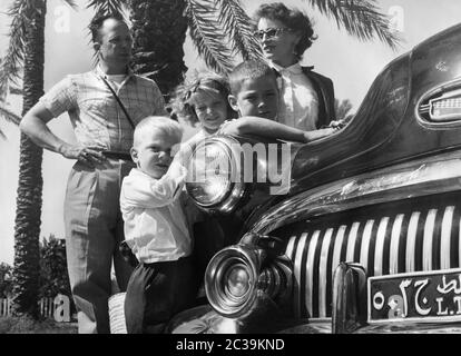 Une famille américaine avec une voiture de fonction Buick à partir du début des années 1950, lors d'un séjour à l'étranger dans un pays arabe dans les années 1950. Banque D'Images