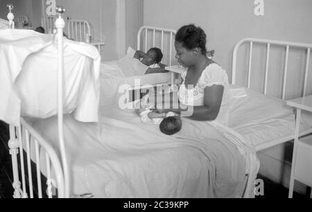 Une jeune mère change la couche de son enfant dans un hôpital de l'ancienne colonie britannique d'Antigua. La photo a été prise lors de la visite de la reine Elizabeth à Antigua en 1966. Banque D'Images