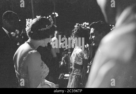 Lors de sa visite à Antigua, dans l'île des Caraïbes, Elizabeth II est accueillie par une fille locale et sa mère. Banque D'Images