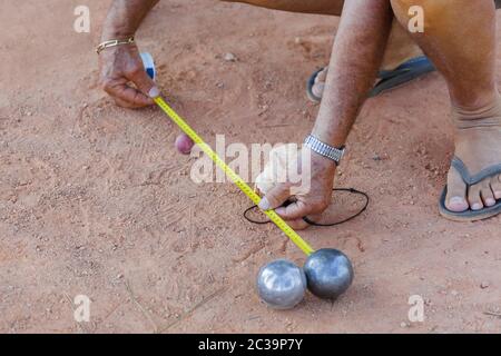 L'homme mesure la distance entre les balles pendant le jeu de pétanque Banque D'Images