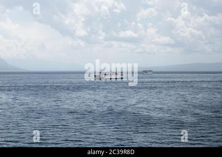 Deux ferries croates se passant l'un l'autre en mer, naviguant vers les îles et à Split lors d'une journée froide pluvieuse. Nuages sombres et mer sombre Banque D'Images