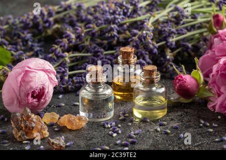 Trois bouteilles d'huile essentielle avec résine d'encens, fleurs de rose de chou et lavande Banque D'Images