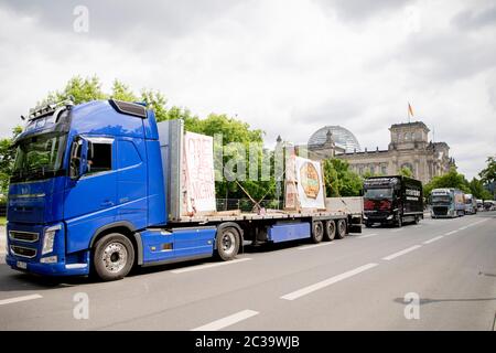 Berlin, Allemagne. 19 juin 2020. Les camions se trouvent dans une parade de camions contre les prix de dumping pour le transport et l'expédition devant le bâtiment du Reichstag. Sur la zone de chargement d'un camion, un panneau indique « sans nous rien ne marche » et « pas de salaire de vidage ». Selon les organisateurs, environ 100 véhicules, y compris des camions articulés et des fourgonnettes, étaient sur la route pour se rendre de la station-service Avus à la porte de Brandebourg à partir du matin. Credit: Christoph Soeder/dpa/Alay Live News Banque D'Images