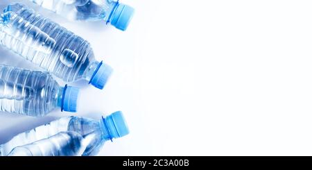 Plusieurs bouteilles d'eau potable sur fond blanc Banque D'Images