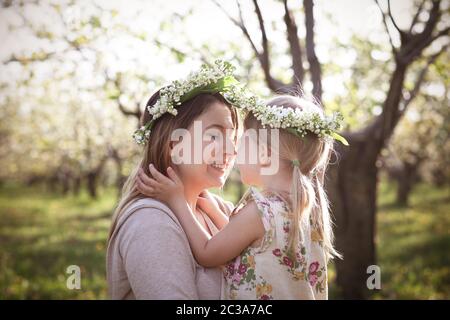 Heureuse mère et sa petite fille dans la journée de printemps dans un jardin en fleurs Banque D'Images