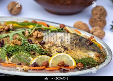 Carp avec citron, les noix et les raisins secs sur la plaque Banque D'Images