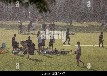 Après un après-midi de soleil et de températures chaudes pendant le maintien du coronavirus britannique, une pluie soudaine et torrentielle attire les utilisateurs du parc par surprise, à Ruskin Park, un espace vert public à Lambeth, le 14 juin 2020, à Londres, en Angleterre. Le nombre actuel de décès de Covid-19 au Royaume-Uni s'élève désormais à 41,662, soit une augmentation par rapport aux 24 dernières heures de 181, Bien que le Premier ministre Boris Johnson soit sous pression pour examiner les arguments en faveur d’une réduction de la règle de la distance sociale de 2 mètres, en raison de son effet sur l’emploi et l’économie en général. Banque D'Images