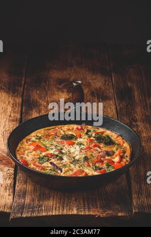 Frittata aux légumes avec le brocoli, poivron rouge et oignon rouge dans la poêle en fonte Banque D'Images