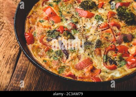 Frittata aux légumes avec le brocoli, poivron rouge et oignon rouge dans la poêle en fonte Banque D'Images