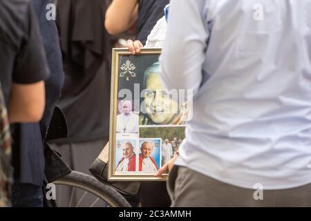 Ratisbonne, Allemagne. 19 juin 2020. Une femme attend avec une photo du Pape Benoît XVI, en face de la maison de Georg Ratzinger, frère malade du Pape émérite. Benoît XVI est revenu en Allemagne pour la première fois depuis sa démission il y a plus de sept ans. Crédit : Armin Weigel/dpa/Alay Live News Banque D'Images