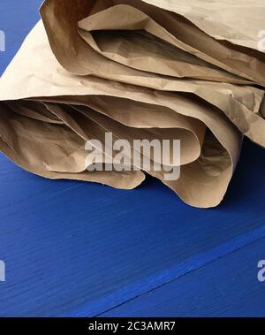 feuille de papier kraft marron froissé sur fond bleu en bois, gros plan Banque D'Images