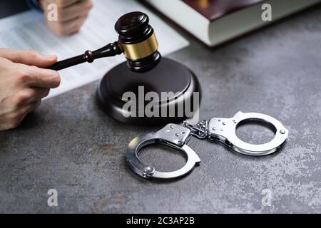Close-up d'un juge Part Substitution Gavel avec des menottes sur 24, dans la salle d'audience Banque D'Images