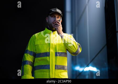 Portrait de jeune gardien de sécurité à l'aide de talkie walkie Radio Banque D'Images