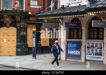 Un homme portant un masque facial protecteur passe devant le Noel Coward Theatre fermé et le monta dans le pub Salisbury dans le centre de Londres, tandis que les théâtres restaient fermés pour des spectacles en raison de mesures de confinement du coronavirus. De nombreuses productions ont pris la décision de ne pas rouvrir avant 2021 et il est prévu que plusieurs mois de préparation pour les productions soient remontés et la confiance du public et les ventes d'avance à construire une fois les restrictions de distance sociale levées pour les salles. Banque D'Images