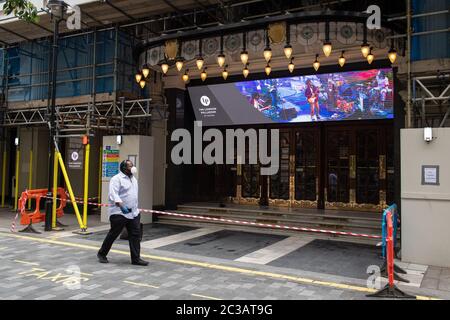 Un homme portant un masque facial protecteur passe devant le théâtre London Palladium fermé dans le centre de Londres, tandis que les théâtres sont restés fermés pour des représentations en raison de mesures de verrouillage du coronavirus. De nombreuses productions ont pris la décision de ne pas rouvrir avant 2021 et il est prévu que plusieurs mois de préparation pour les productions soient remontés et la confiance du public et les ventes d'avance à construire une fois les restrictions de distance sociale levées pour les salles. Banque D'Images