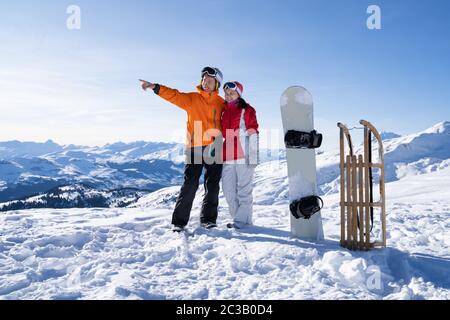 Portrait d'un jeune couple sympathique, debout près de Snow Board et traîneau en bois dans la neige Banque D'Images