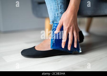 Close-up of Woman's Hand Holding Cool Pack Gel Sur la cheville Banque D'Images