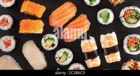 Grand panorama de sushi, gros plan sur fond noir. Un assortiment de maki, nigiri et rouleaux Banque D'Images