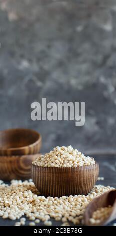 Grain du Sorgho blanc cru dans un bol sur une table en bois Banque D'Images