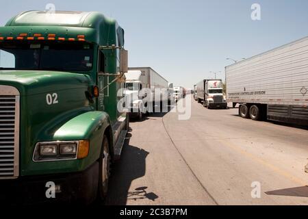 Laredo, Texas USA, 2012: Des milliers de camions par jour traversent le Mexique vers les États-Unis sur le pont du Commerce mondial, le plus grand port commercial le long de la frontière entre le Texas et le Mexique. À un poste des douanes et de la protection des frontières des États-Unis, au pont, une longue ligne de camions attend d'être recherchée pour trouver des drogues ou d'autres marchandises de contrebande cachées dans les véhicules avant d'être autorisée à passer aux États-Unis ©MKC / Daemmrich photos Banque D'Images