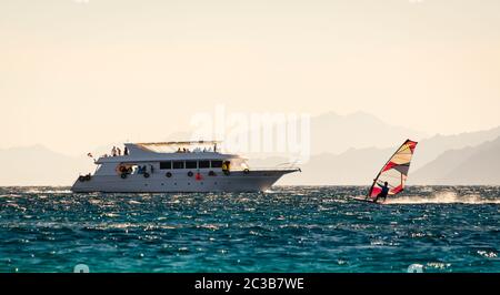 Grand bateau et planche à voile sur le fond des hautes montagnes en Egypte Dahab Sud Sinaï Banque D'Images