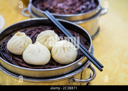 Délicieux petits pains chinois Baozi traditionnels, petits pains cuits à la vapeur remplis de viande de porc mouchée et de chou préparés à la vapeur chaude, cuits à la vapeur. Chine Banque D'Images