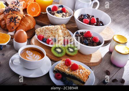 Le petit-déjeuner est composé de café, jus d'orange, croissants, crêpes, œufs, céréales et fruits. Banque D'Images