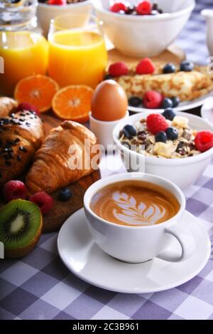 Le petit-déjeuner est composé de café, jus d'orange, croissants, crêpes, œufs, céréales et fruits. Banque D'Images